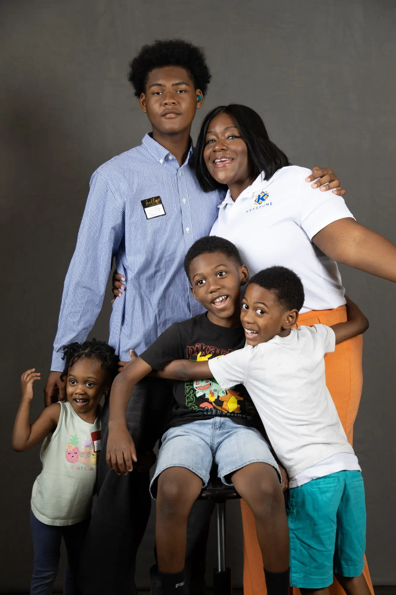 A caregiver and children enjoying a playful family portrait experience hosted in connection with KSA