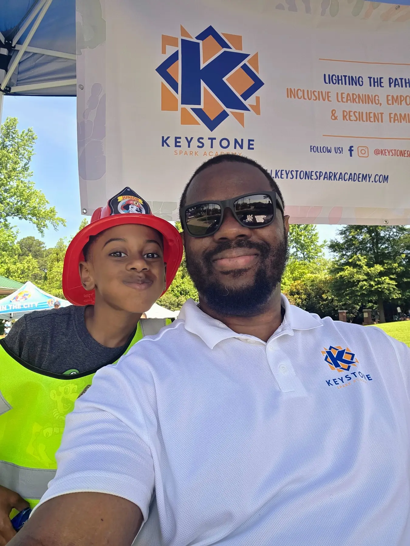 Marc Cesar and a young family member representing Keystone Spark Academy at a community event